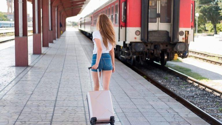 נוסעת עם מזוודה על רציף תחנת רכבת בדרך לאגם בלטון